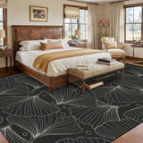 Bedroom with a wooden bed above a 9x12 ft area rug, black and gray botanical leaf line pattern