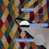 Close-up of the rug, burgundy, blue and mustard harlequin diamonds, with a folded corner showing binding and backing