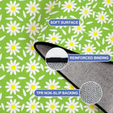 Close-up of the rug, bright green with white daisies, with a folded corner showing binding and backing