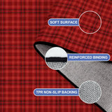 Close-up of the rug, red and black plaid, with a folded corner showing binding and backing
