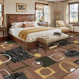 Brown geometric area rug at the foot of a bed in a bedroom with leather headboard