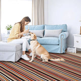 Red black white striped area rug 8x10 ft in a living room where a woman and dog sit by a blue sofa