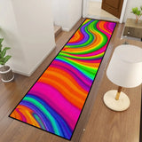 Rainbow swirl hallway runner rug seen from above beside a white table lamp on a wood floor