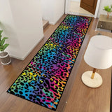 Rainbow leopard print hallway runner rug beside a white table lamp on a wood floor