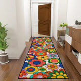 Colorful flower pattern hallway runner rug in a hallway leading to a wooden door, with a console and plant