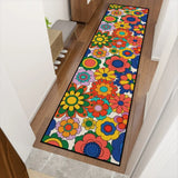 Colorful flower pattern hallway runner rug angled along a wooden hallway floor near stairs and a plant