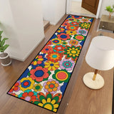 Colorful flower pattern hallway runner rug seen from above beside a white table lamp on a wood floor