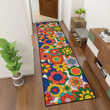 Colorful flower pattern hallway runner rug in a narrow hallway next to a green plant and shoe bench