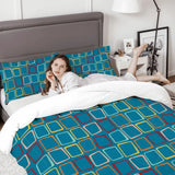 Woman relaxing on a bed with the square print comforter set and a gray headboard