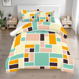 Queen comforter set with mustard, mint and peach color blocks on a bed with two bedside tables