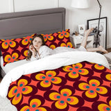 Woman relaxing on a bed with the flower power comforter set and a gray headboard
