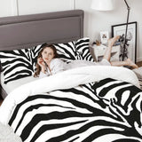 Woman relaxing on a bed with the zebra print comforter set and a gray headboard
