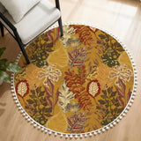Round rug with white pom pom edge and mustard brown leaf print beside a white armchair