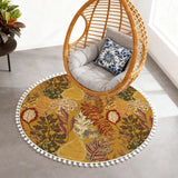 Mustard leaf-print round rug with pom poms under a hanging rattan egg chair