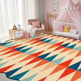 Red and teal triangle-pattern scalloped area rug in a nursery with crib and pink canopy