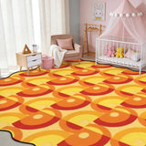 Orange and yellow circle-pattern scalloped area rug in a nursery with crib and pink canopy