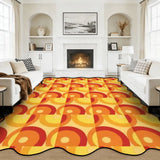 Orange and yellow circle-pattern scalloped area rug in a living room with fireplace and white sofas