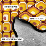 Close-up of yellow and brown tile-pattern scalloped rug corner with black binding and gray non-slip backing