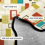 Close-up of cream multicolor rectangle-pattern scalloped rug corner with black binding and gray non-slip backing