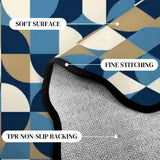 Close-up of blue and cream geometric scalloped rug corner with black binding and gray non-slip backing