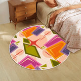 Colorful geometric round rug beside a bed and wooden nightstand on a wood floor