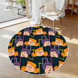 Round rug with white border and navy cartoon-face pattern beside a white armchair on a wood floor