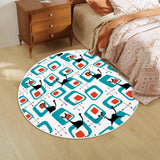 Round rug with teal squares and black cats beside a bed and wooden nightstand